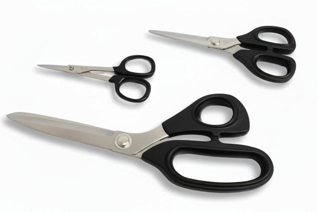 Three pairs of scissors with different models on a textured surface