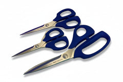 three pairs of blue-handled scissors on a colorful fabric background with visible model numbers.