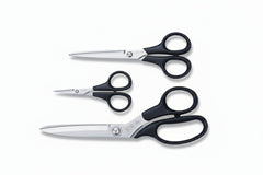 Three pairs of scissors with different sizes on a blue cutting mat with KAI branding.