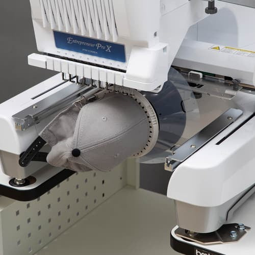 Embroidery machine with a cap being embroidered, branded 'Entrepreneur Pro X'.